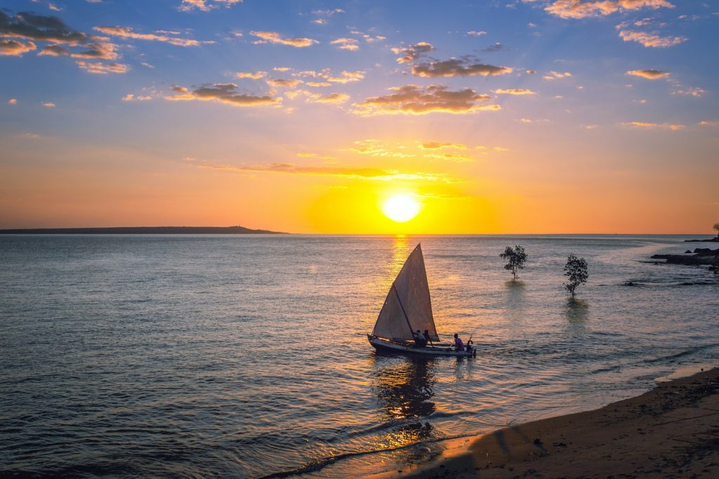 silhouette of people riding on sail boat on sea during sunset